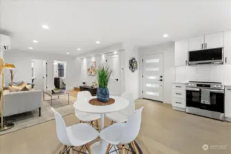 Open concept kitchen, living, and dining area with an oversized panty/coat storage under the stairs.