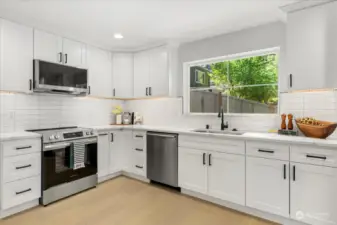 Brand new kitchen with shaker cabinets, 3cm quartz countertops, subway tile backsplash, under cabinet lighting, and stainless appliances.