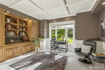The office or study is off the foyer and features a wall of built-in cabinetry, wainscoting and tray ceiling.