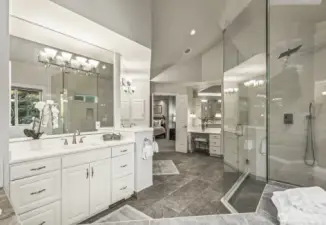 Updated 5 piece bathroom with designer tiled floor and shower, 2-person jetted tub, crisp white cabinetry with separate quartz vanities.