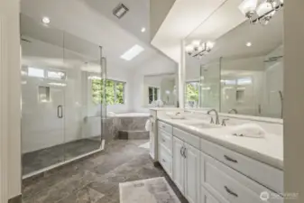 Uplifting and updated 5 piece bathroom with designer tiled floor and shower, 2-person jetted tub, make-up vanity, crisp white cabinetry with separate quartz vanities.