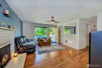 Living room with Pergo flooring and a wood burning brick fireplace.