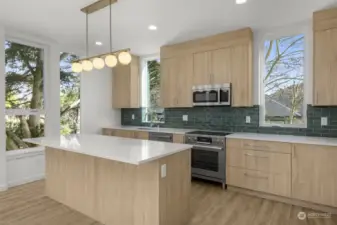 The light wood cabinets & dark green backsplash contrast for a calming, PNW vibe!
