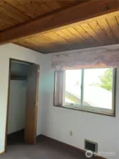 First guest bedroom with warm wood ceilings.