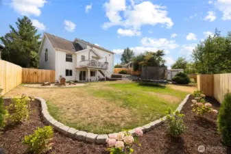 The backyard is fully fenced in, with a stunning firepit area, refreshed landscaping and storage shed.