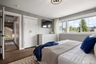 The oversized primary bedroom, with beautiful windows, a closet and ensuite bathroom.