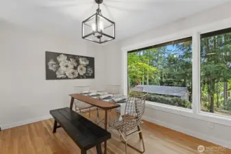 This lovely dining space looks out through gorgeous new windows to your evergreen backyard.