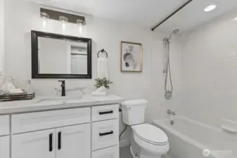 Freshened up with a new vanity, countertops, lighting and fixtures is this full, hall bath on the main level.
