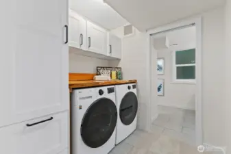 Downstairs laundry center with newer machines and a stunning folding surface lovingly created from a felled tree on the property.