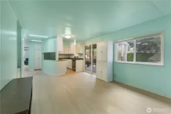 Looking back into the kitchen from a second living area. The covered patio can be accessed through a slider to the right of the kitchen