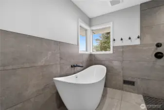 Soaking tub with heater floors in bathroom