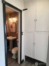 Bathroom and hallway with plenty of storage space.,