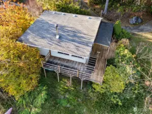 Aerial view of cabin, decks and mature landscape.