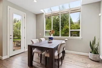 Adjacent to the kitchen, a bright dining nook features clean lines and expansive windows that frame backyard views.