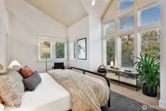 Soaring ceilings and abundant windows in the primary bedroom suite.