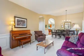 The living room with formal dining room in the background. Arched doorways give character to the space.