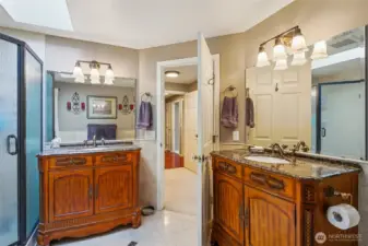 The en-suite bathroom offers 2 separate sinks, storage cabinets, Travertine flooring and more.