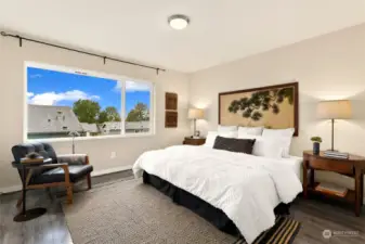 A bright en-suite primary bedroom on the upper floor, with picturesque window.