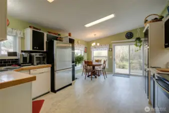 Remodeled kitchen with newer appliances, dining space, and side door.