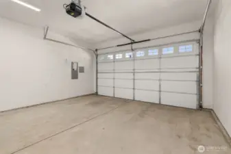 Two car garage with opener, walls are fully primed for a finished look.