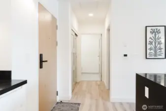 Entry hallway to stackable washer/ dryer closet, entry closet and 1/2 bath.