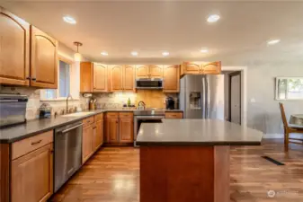 Kitchen boasts updated lighting, tile backsplash and low profile microwave.