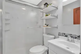 Comfortable three piece bathroom with shelving.