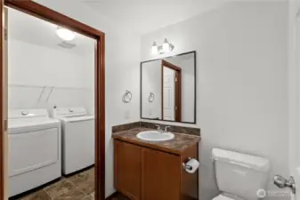 Main floor half bathroom conveniently located with a subtly connected laundry room for added functionality.