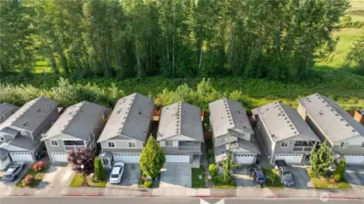 Beautiful tall trees lining the back of the property create a stunning natural backdrop.