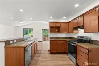 The kitchen is the heart of the home with a spacious island, recessed lighting, and new electric stove/range and dishwasher.