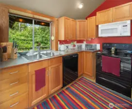 Big kitchen window overlooks the eastern entrance to the property. Plenty of nice cabinetry.