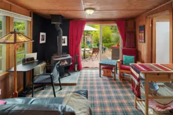 The main living space of DADU with cozy wood stove. Bathroom is through the doorway to right.