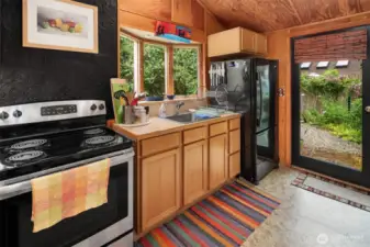 All you need in a kitchen! Window faces north, door opens out to east. Warm wood vaulted ceilings in this space, too.