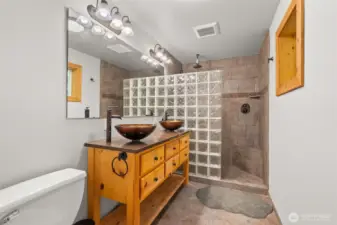Primary bath with walk in tile shower and double sink vanity