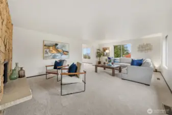 The living room is a bright, restful space with neutral paint and new carpet. A stone accent fireplace adds warmth and character to the room.