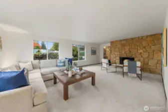 The living room is elegantly designed with a large picture window that brings in ample natural light to create a warm and inviting atmosphere. It's the ideal space for spending evenings at home in Bellevue, especially next to the charming wood fireplace.