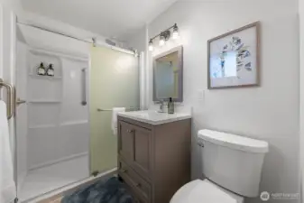 Welcome to the Primary Suite's updated bath. It features updated vanity, quartz countertop, and updated fixtures. Notice the nice shower surround that provides a great look with easy maintenance.