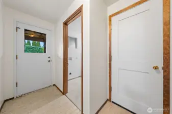 This lower-level hallway offers access to the backyard through a rear entry door. It also connects to the utility room and a separate storage space for added convenience.