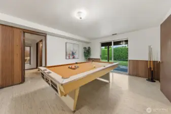 The family room opens directly to the backyard through sliding glass doors, creating a great indoor-outdoor connection. The hallway leads to two additional bedrooms and a full bathroom, offering flexible living options.