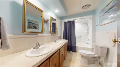 Primary bath with tub and shower and two sinks.