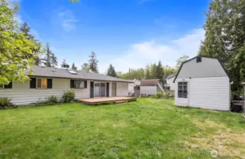 Large, level backyard with deck, shed, and compost bin