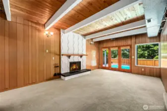 Cool downstairs living space with wood burning fireplace and french doors to outdoor pool.