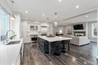 Top-tier stainless appliances, dual dishwashers, and gleaming engineered hardwoods elevate the kitchen.