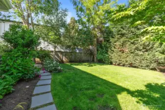 Generous outdoor space featuring a large, manicured lawn surrounded by mature landscaping, offering plenty of room for play and relaxation.
