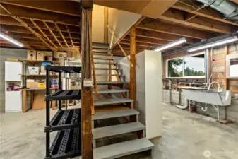 Stairs to utility area of basement with high ceilings and room to create