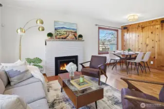 Cozy open concept with gas burning fireplace and original wood floors.