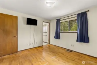 Clean slate with room to dream—this bedroom offers hardwood charm, a peek into the en suite, and built-in TV zone (cord concealer, anyone?)