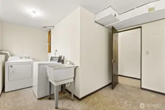 Roomy and ready to work—this utility space features a washer, dryer, deep utility sink, and space for folding, sorting, or leveling up your laundry game.