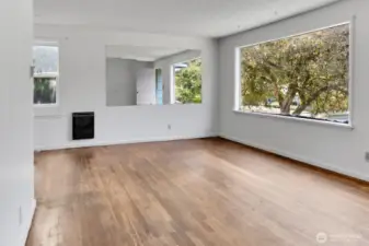 Main living room with hardwood floors and a big west facing window.