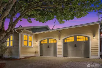 Two car garage with beautiful custom doors and brick paver driveway gives excellent curb appeal.